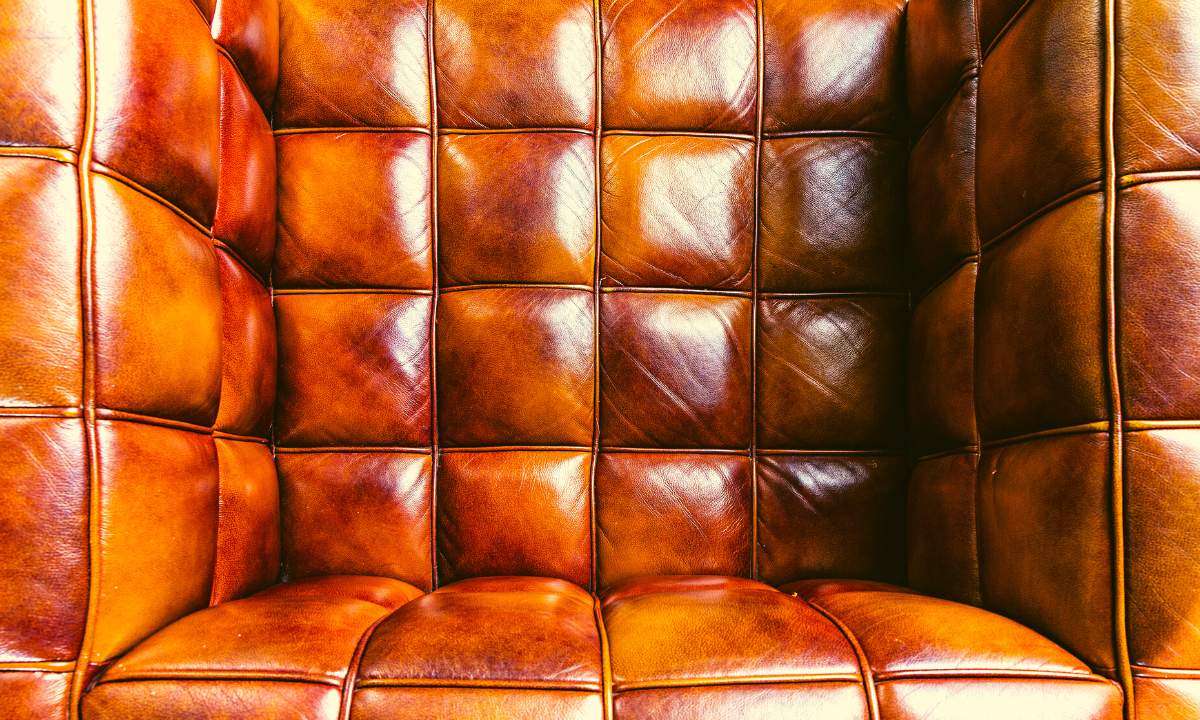 A brown leather chair shows discoloration from sweat stains.
