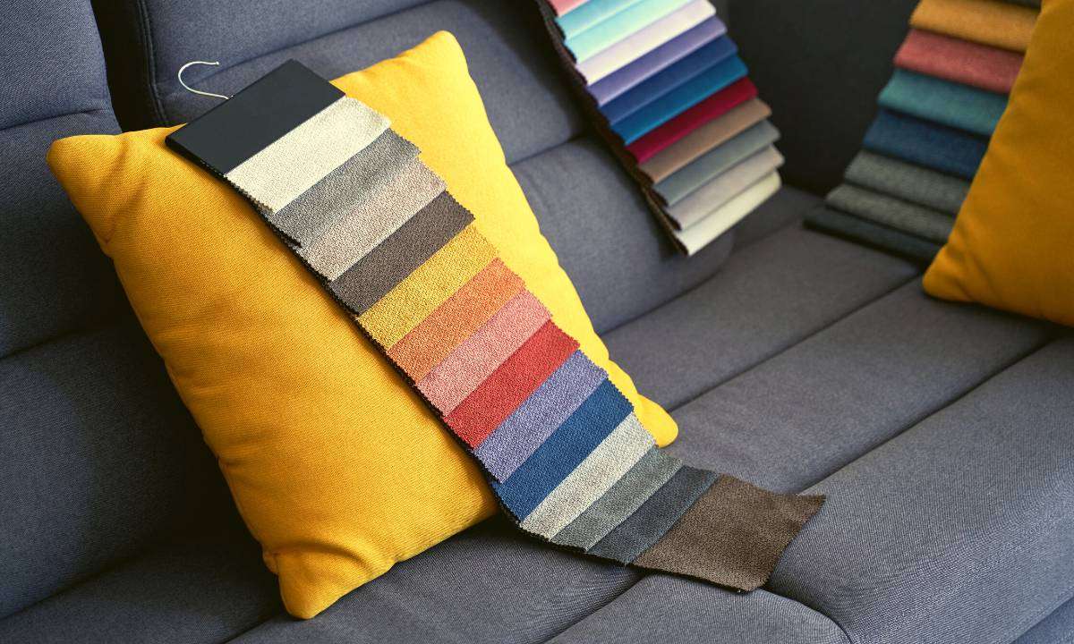 An upholstered sofa with fabric swatches on it.