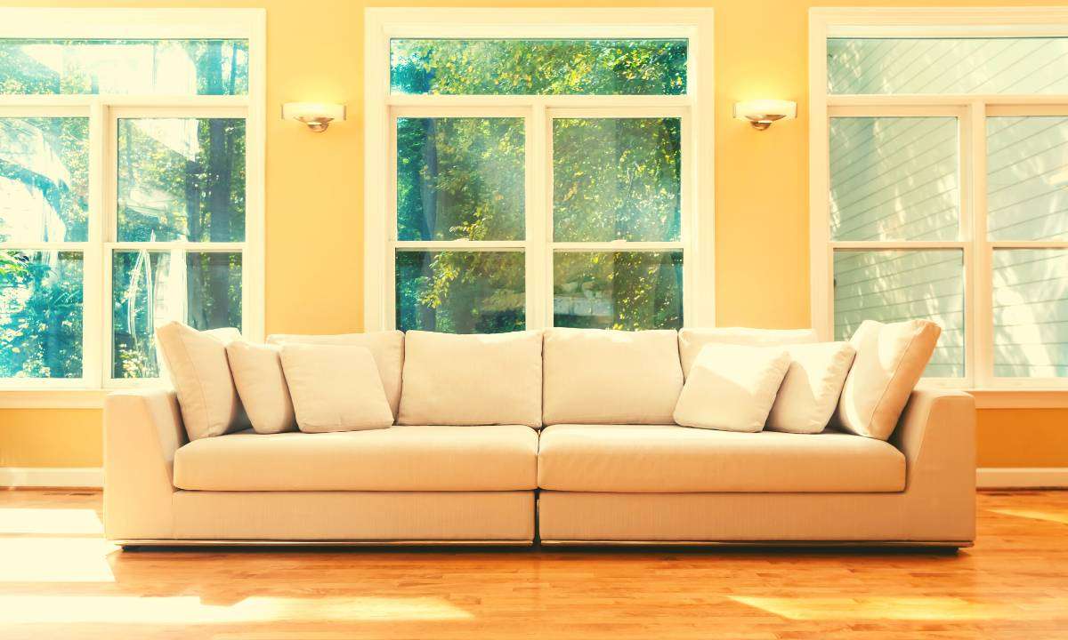 A long white sectional sofa in a sunny living room.