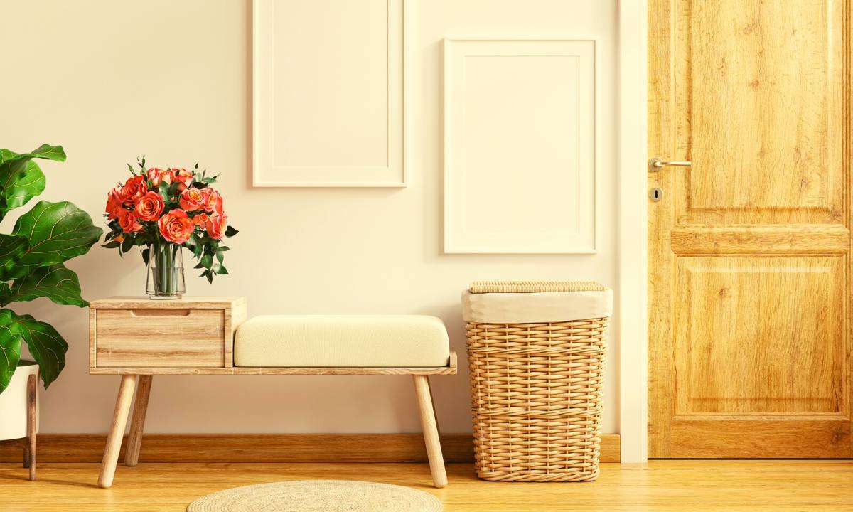 A simple Scandinavian-style light-wood bench against a white wall.